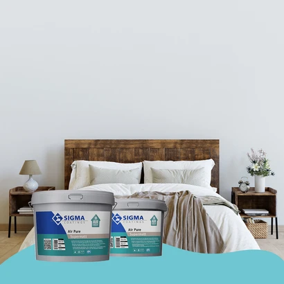 Slaapkamer met een modern houten bed, witte en beige beddengoed en minimalistische nachtkastjes. De muur is egaal wit geschilderd. Op de voorgrond staan twee emmers Sigma Air Pure Supermatt muurverf.