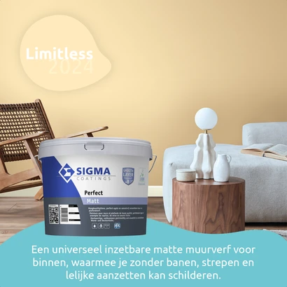 Modern interieur met een zachtgele muur in de kleur Limitless 2024. Op de voorgrond staat een emmer Sigma Coatings Perfect Matt. Links staat een rotan stoel, rechts een lichtgrijze bank met een houten bijzettafel en een witte tafellamp. Onderin beeld st