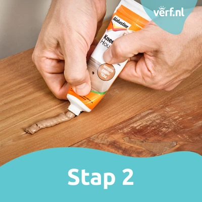 Stap 2: Kneedbaar Hout in kleur Teak wordt aangebracht in de scheur.