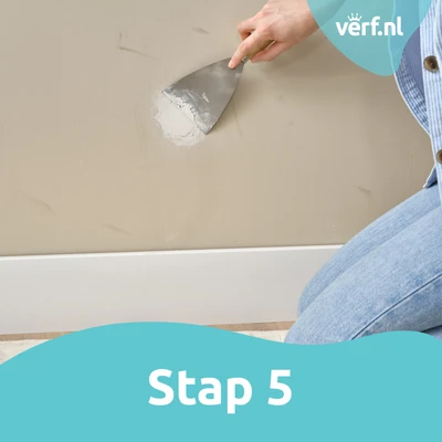 Stap 5: Gladstrijken: Het oppervlak wordt netjes gladgestreken met een plamuurmes om het gerepareerde gat naadloos te laten aansluiten op de muur.