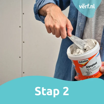 Stap 2: Alabastine Gipsplaatvuller wordt uit de emmer gehaald met een plamuurmes.