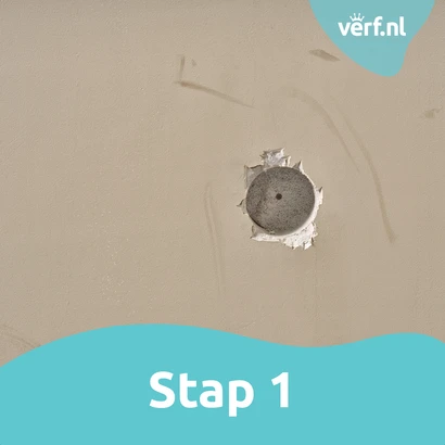 Stap 1: Voorbereiden van het gat: Close-up van een ronde beschadiging in de muur, klaar om gerepareerd te worden met vulmiddel.