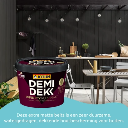Moderne, sfeervolle buitenkeuken met zwarte houten wand, sfeerverlichting en een tafel met stoelen. Op de voorgrond staat een blik Jotun Demidekk Infinity Pure Matt beits met de tekst: "Deze extra matte beits is een zeer duurzame, watergedragen, dekkende